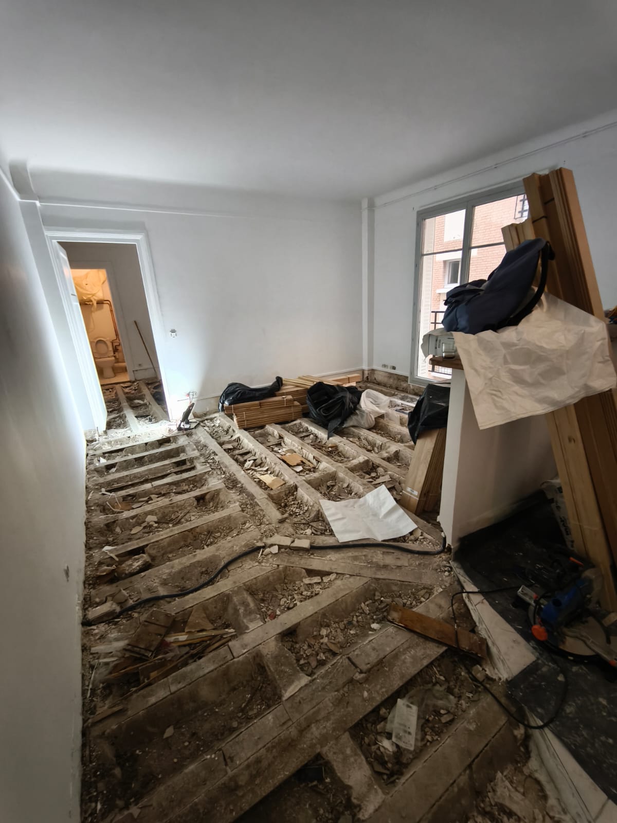 Appartement avant rénovation, sol préparé pour ponçage et ragréage avant pose de parquet